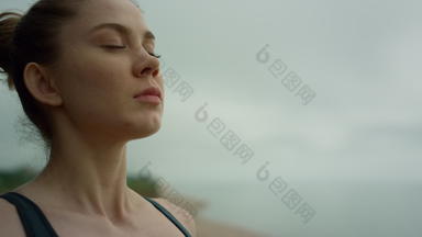 瑜珈女人使深呼吸冥想海滩夫人练习瑜伽关闭